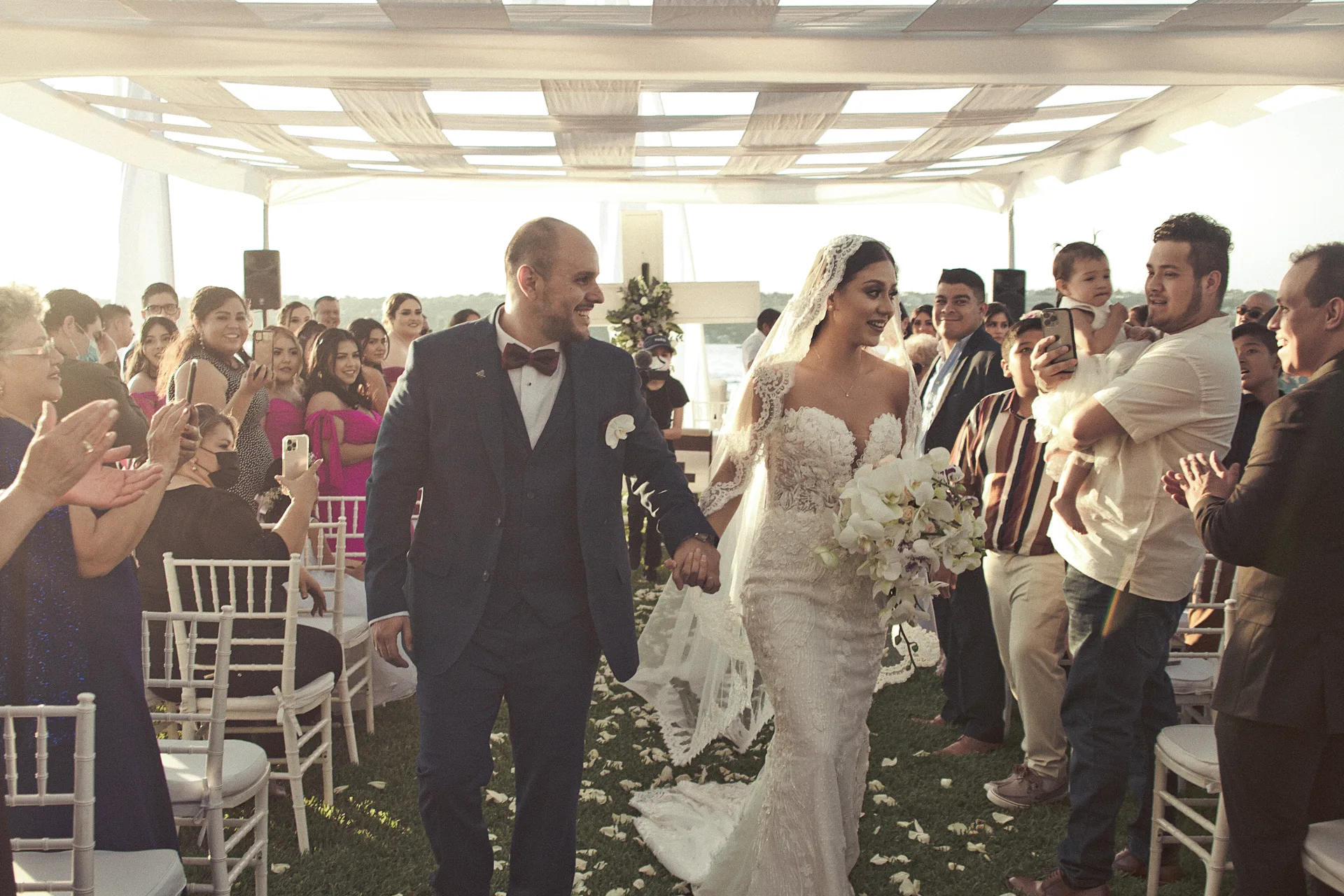Entrada de los novios entre los invitados que aplauden