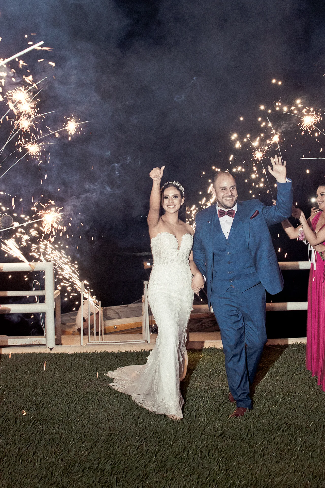 Novios celebrando de noche entre luces de bengala
