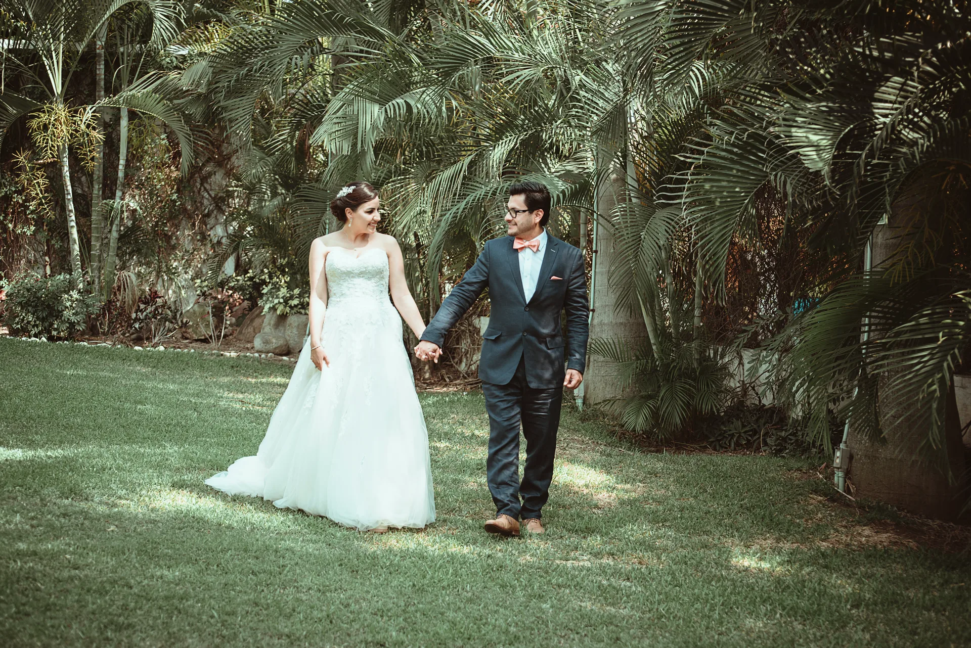 Pareja de novios caminando entre la vegetación del jardín