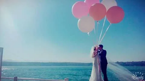 Novios con globos frente al lago después de la ceremonia