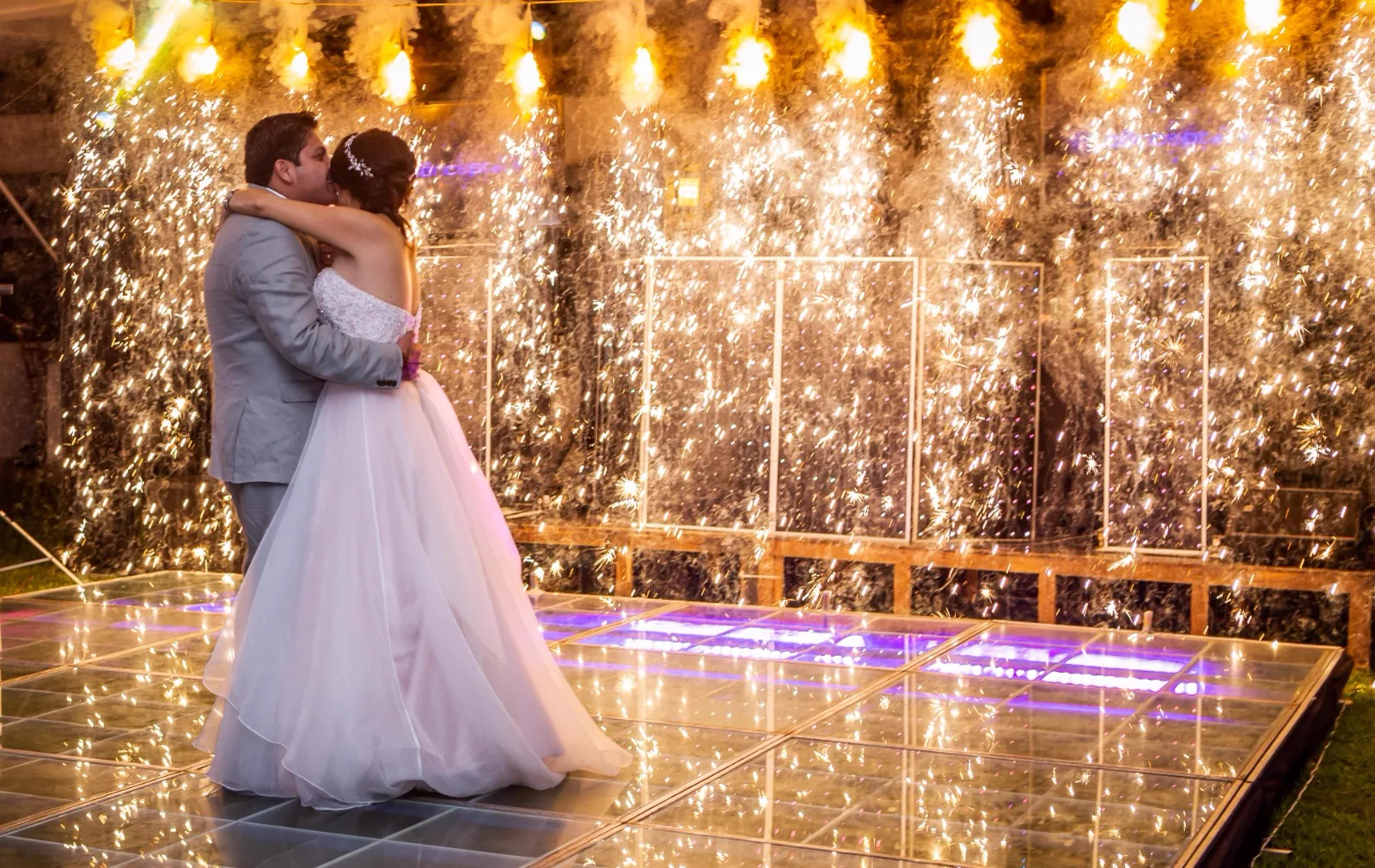 Primer baile de los novios en la pista iluminada con luces frías